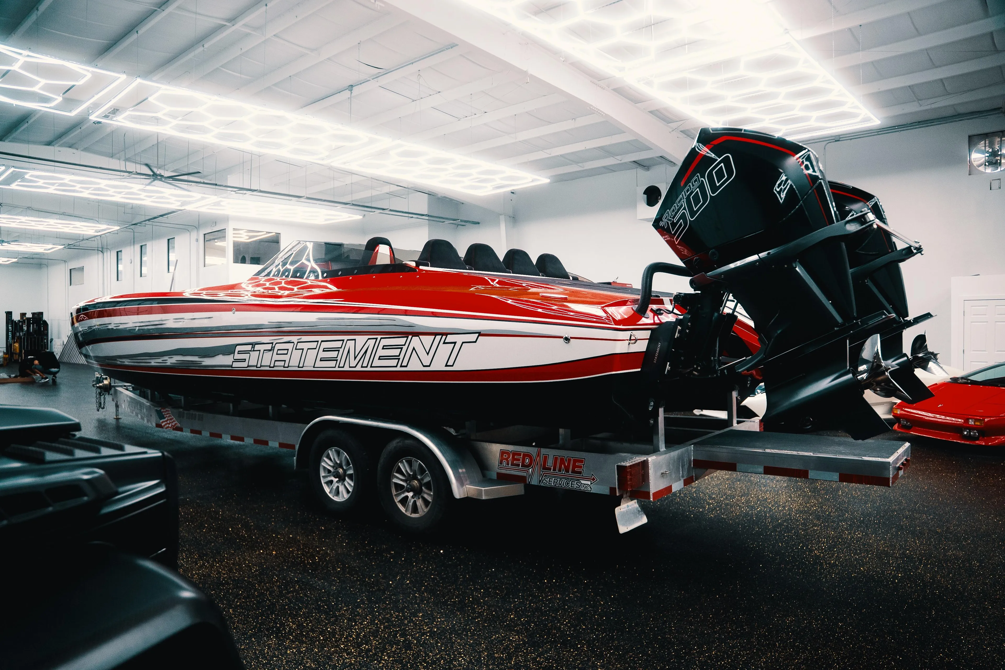 Red 2025 Statement 360 CAT powerboat on trailer in a well-lit garage.