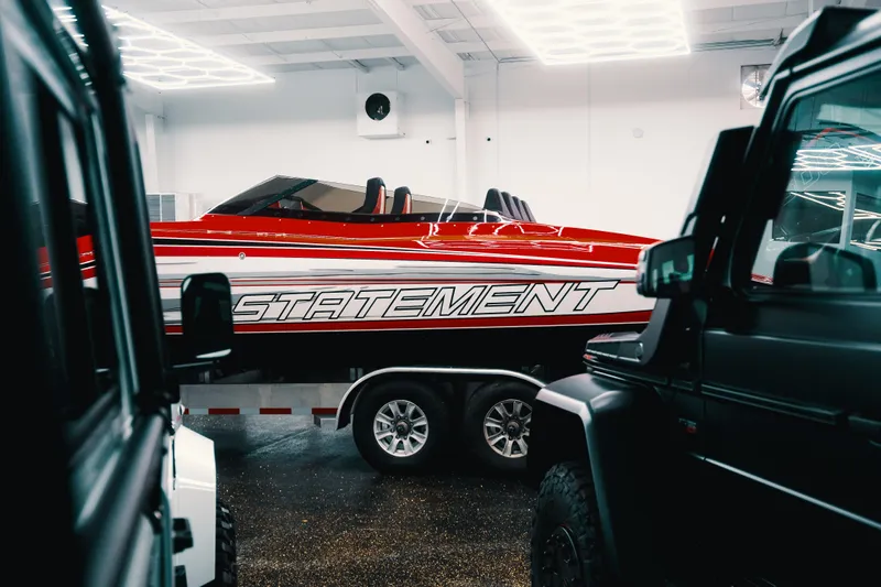  Yacht Photos Pics Red Statement 360 CAT boat on trailer in showroom, surrounded by vehicles.