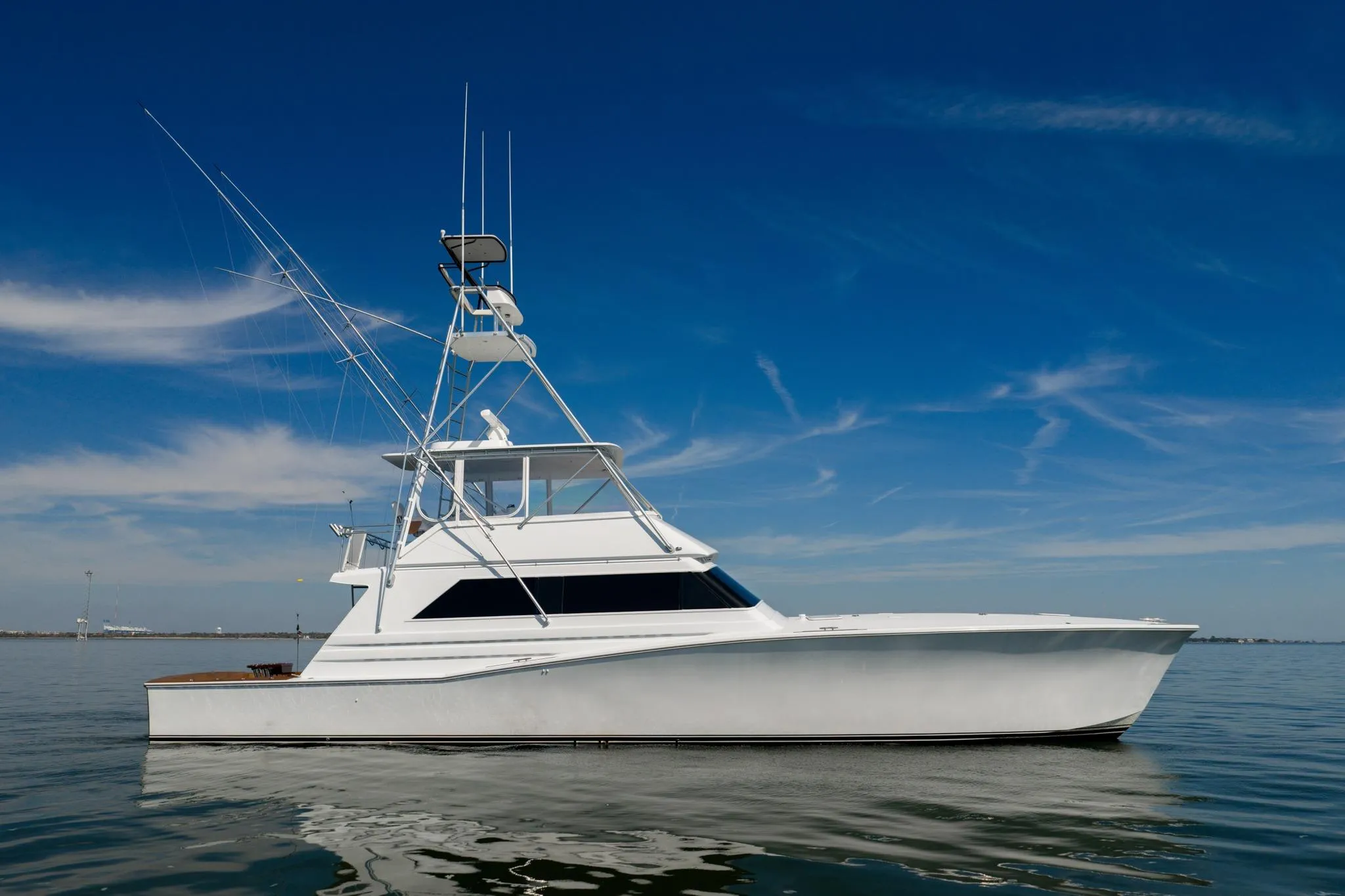 1996 Jim Smith 60 Sportfish yacht on calm water under clear blue sky.
