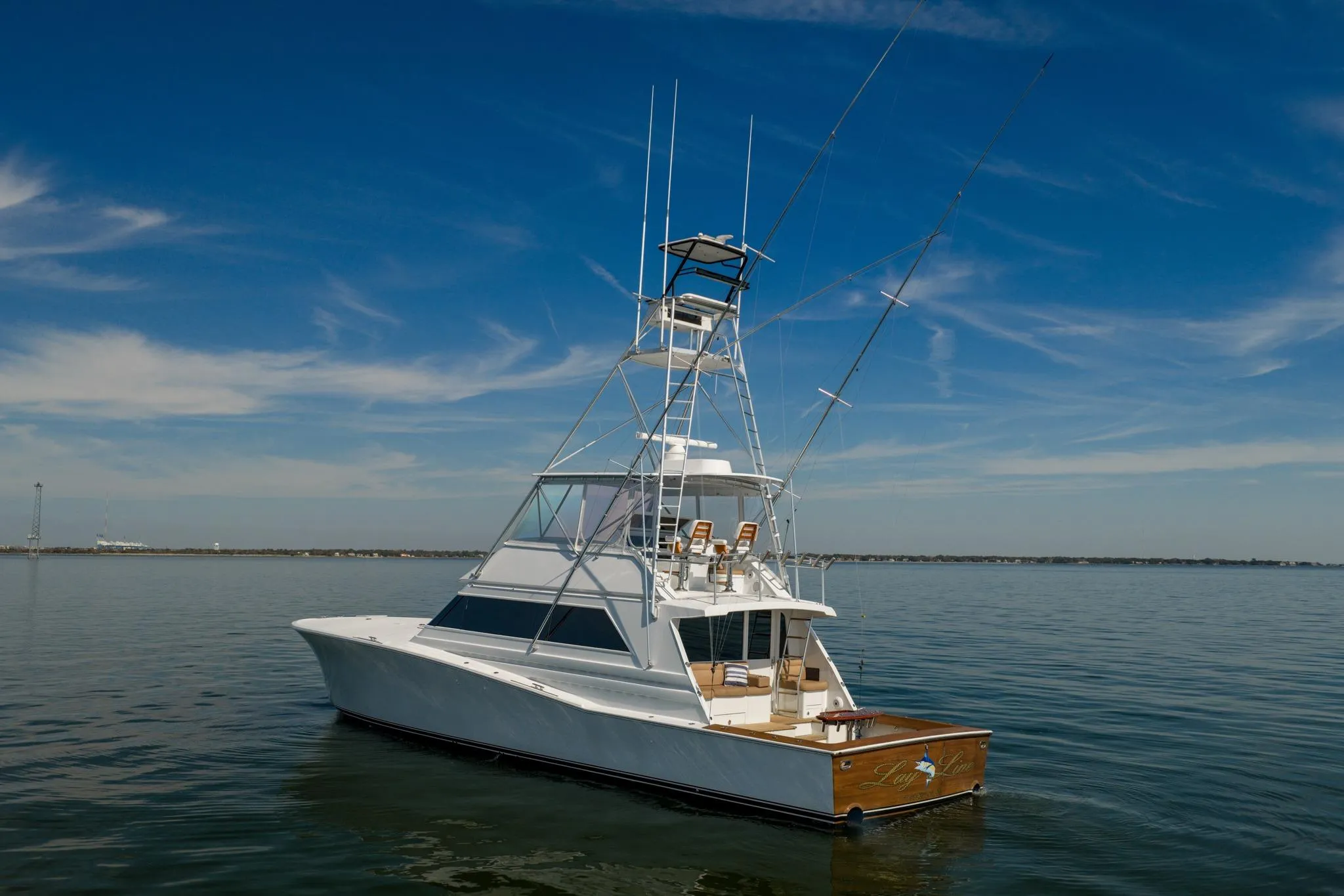 1996 Jim Smith 60 Sportfish yacht on calm water under clear blue sky.
