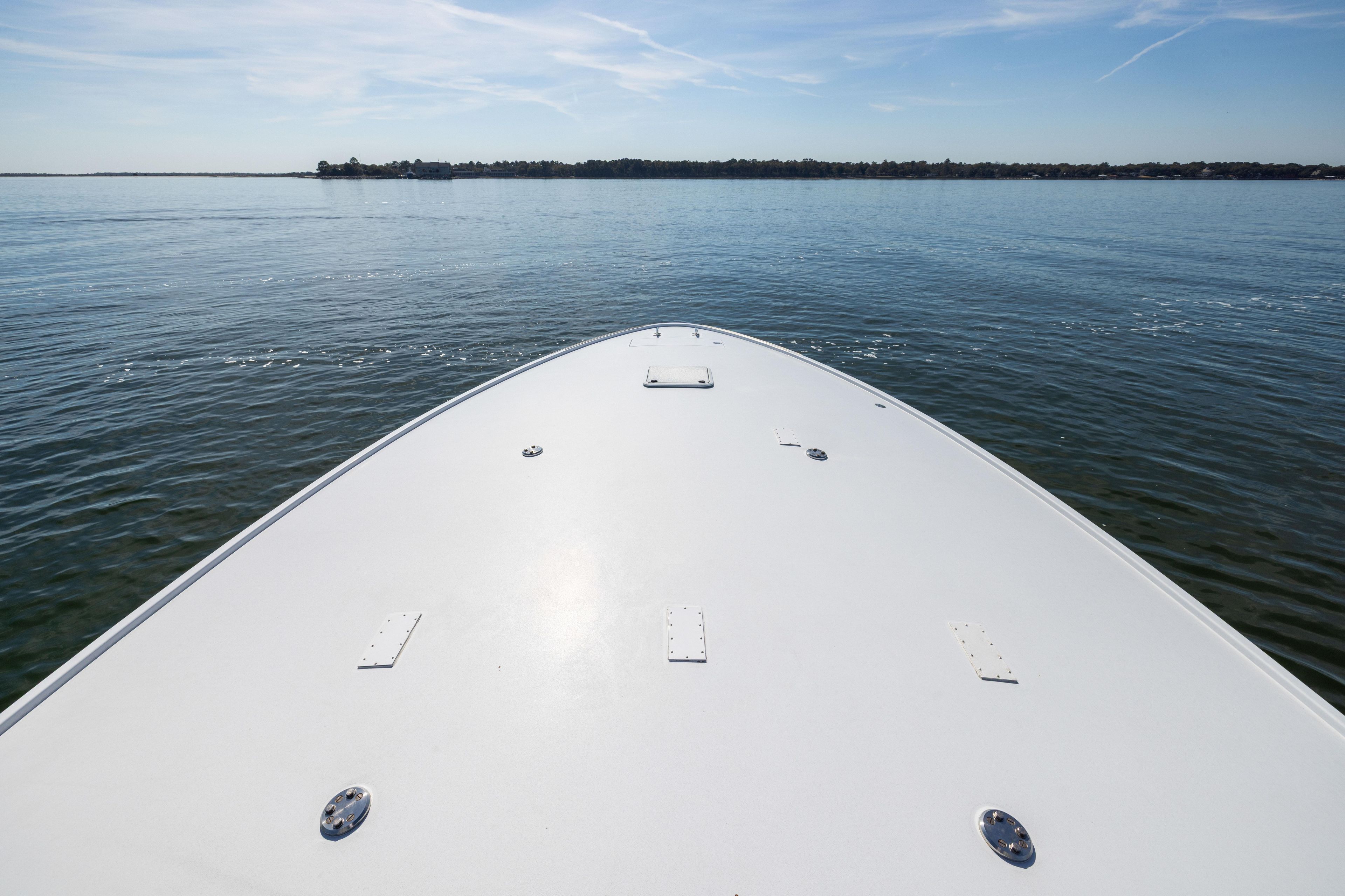 Bow of 1996 Jim Smith 60 Sportfish boat on calm water under clear sky.