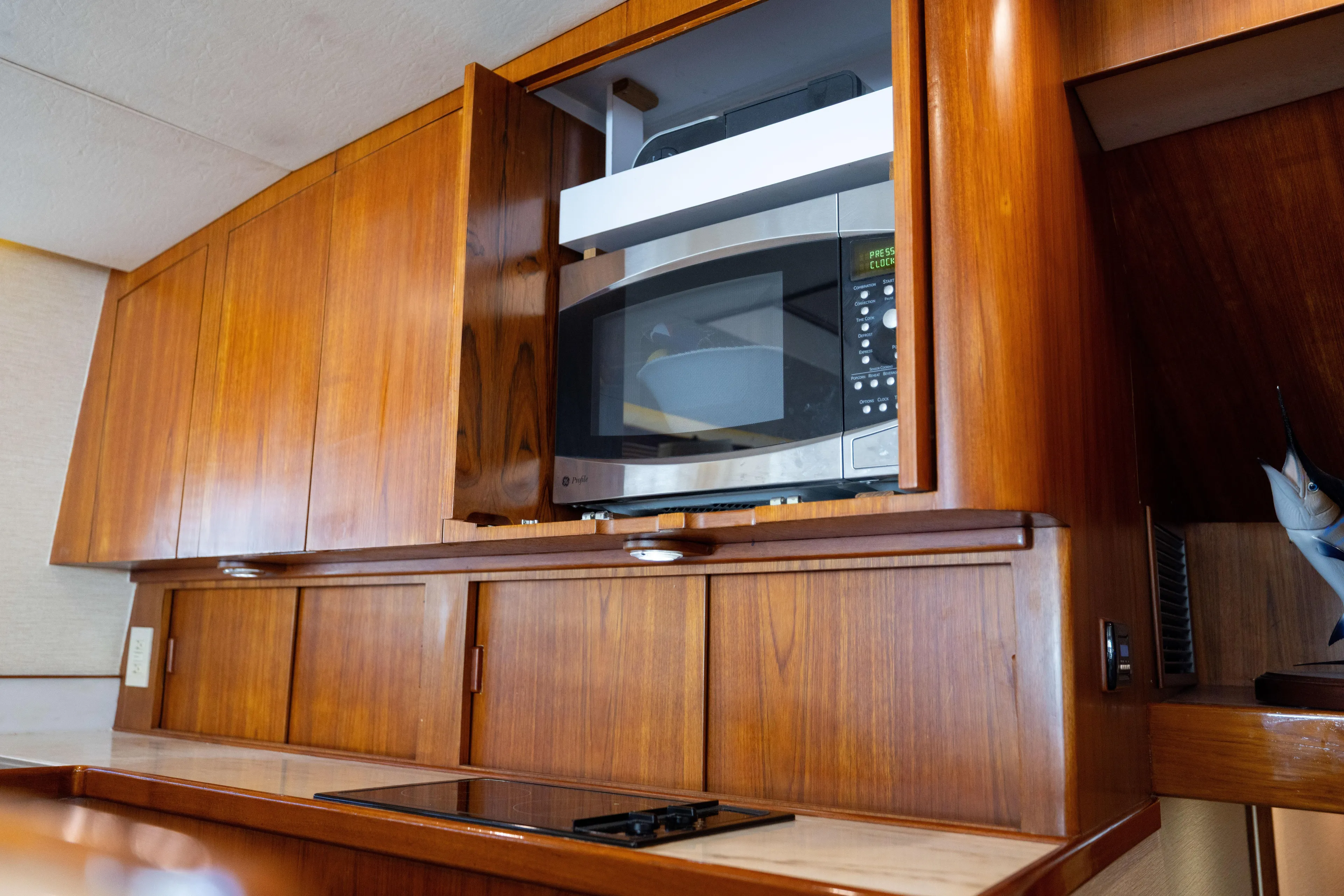 Lay Line Yacht Photos Pics Wooden kitchen cabinetry with built-in microwave on a 1996 Jim Smith 60 Sportfish boat.
