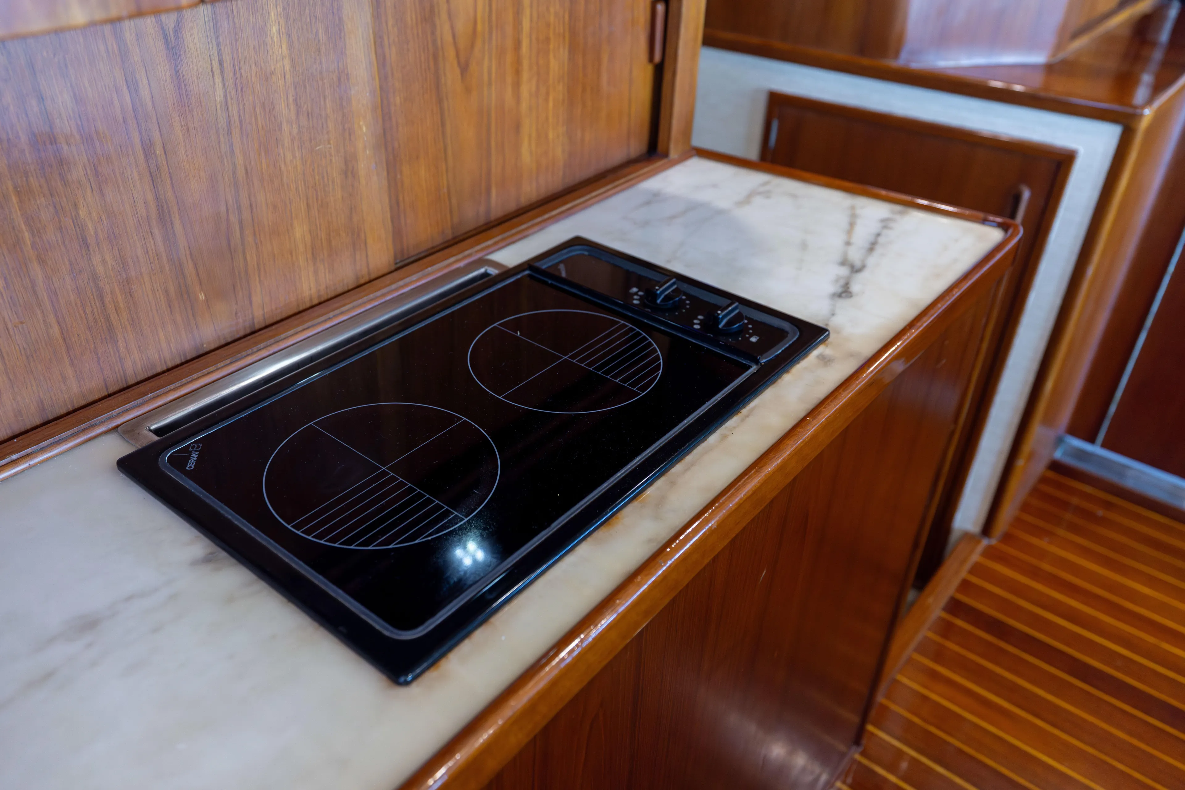 Lay Line Yacht Photos Pics 1996 Jim Smith 60 Sportfish yacht kitchen with electric stovetop and wooden cabinetry.