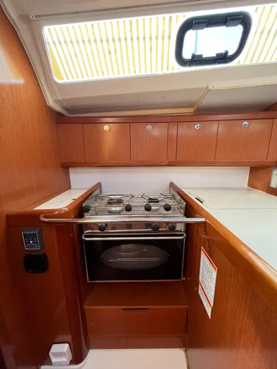 Rosebud Yacht Photos Pics 2008 Beneteau Oceanis 37 yacht kitchen with stove and wooden cabinetry.