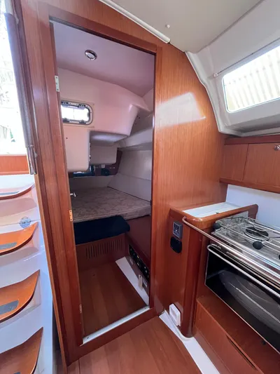 Rosebud Yacht Photos Pics Interior cabin of 2008 Beneteau Oceanis 37 sailboat with wood finish and compact kitchen.