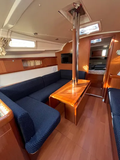 Rosebud Yacht Photos Pics Interior of 2008 Beneteau Oceanis 37 sailboat with blue seating and wooden table.