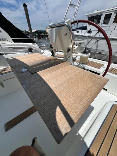 Rosebud Yacht Photos Pics Cockpit of 2008 Beneteau Oceanis 37 sailboat with wooden table and red steering wheel.
