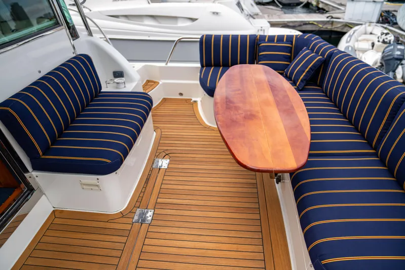  Yacht Photos Pics Luxurious 2015 Sabre 48 Salon Express yacht with striped seating and wooden deck.