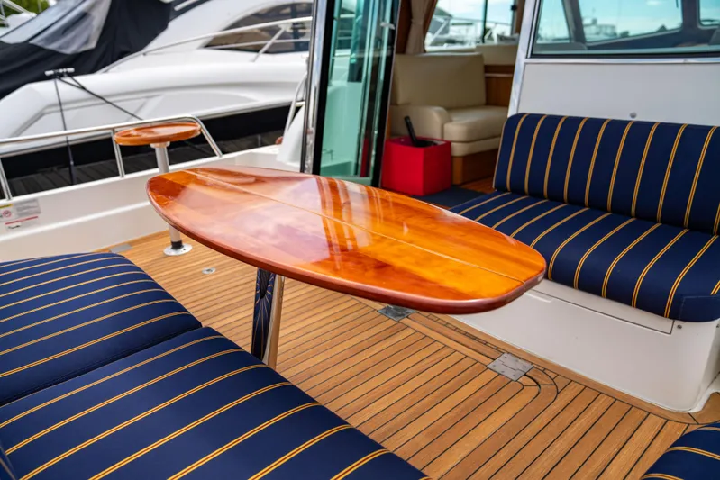  Yacht Photos Pics Interior of 2015 Sabre 48 Salon Express with wooden table and striped seating.