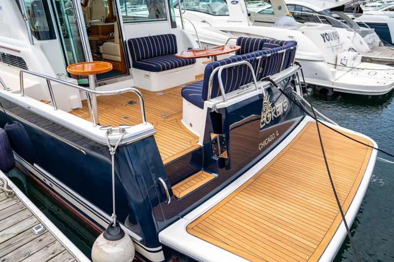  Yacht Photos Pics 2015 Sabre 48 Salon Express yacht with teak deck and striped seating at marina.