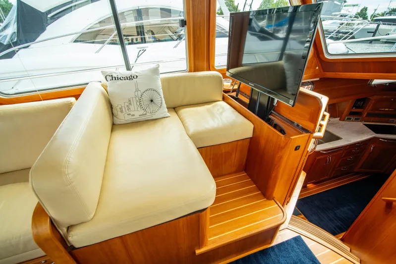  Yacht Photos Pics Interior of 2015 Sabre 48 Salon Express with beige seating and mounted TV.