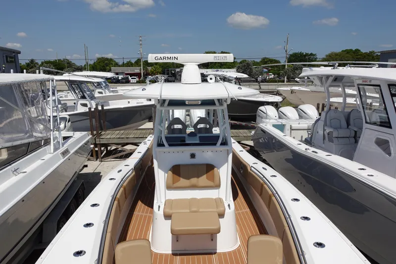  Yacht Photos Pics 2022 Cape Horn 34 XS boat with tan seating, docked among other boats under a clear sky.