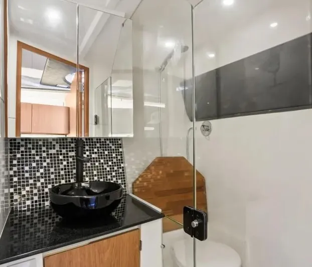  Yacht Photos Pics Modern bathroom in Hanover 355, 2025 model, featuring sleek black sink and glass shower enclosure.