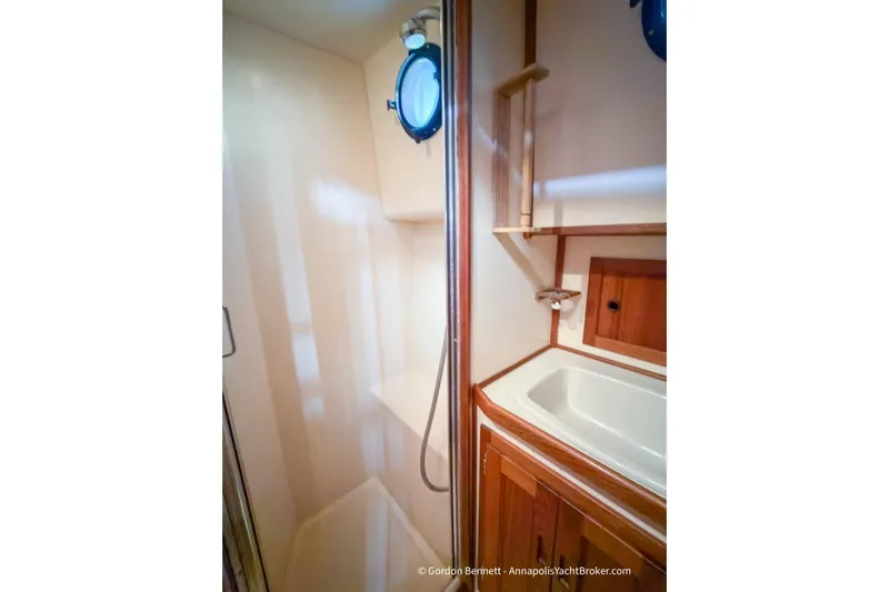Dee Gee Yacht Photos Pics 1999 Nordic Tug 37 bathroom with shower, sink, and porthole window.