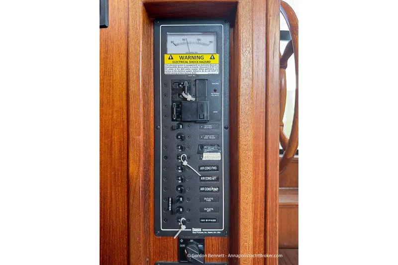 Dee Gee Yacht Photos Pics Electrical panel on 1999 Nordic Tug 37 boat, featuring switches and warning label.