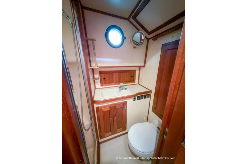 Dee Gee Yacht Photos Pics Bathroom interior of 1999 Nordic Tug 37, featuring wood accents and a porthole window.