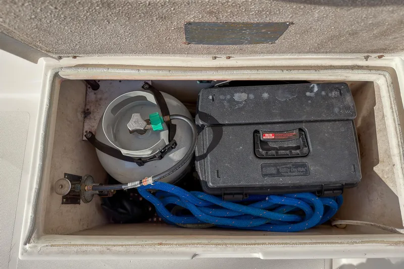 Dee Gee Yacht Photos Pics Storage compartment on a 1999 Nordic Tug 37 with propane tank, toolbox, and blue rope.