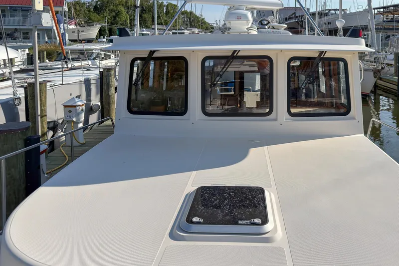 Dee Gee Yacht Photos Pics 1999 Nordic Tug 37 docked at marina, showcasing front deck and windows.