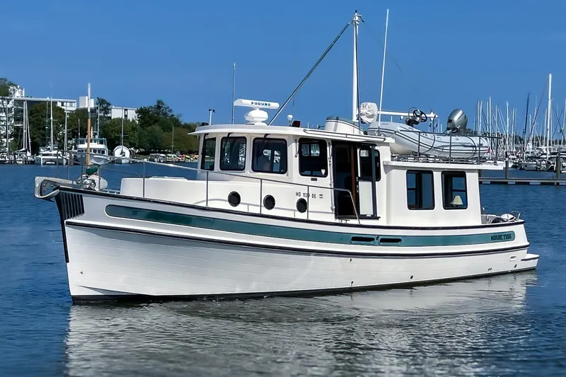 Dee Gee Yacht Photos Pics 1999 Nordic Tug 37 boat docked in a marina, clear blue sky background.