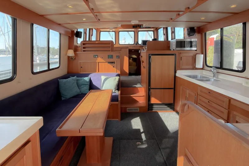 Dee Gee Yacht Photos Pics Interior of a 1999 Nordic Tug 37, featuring a cozy seating area and kitchenette.