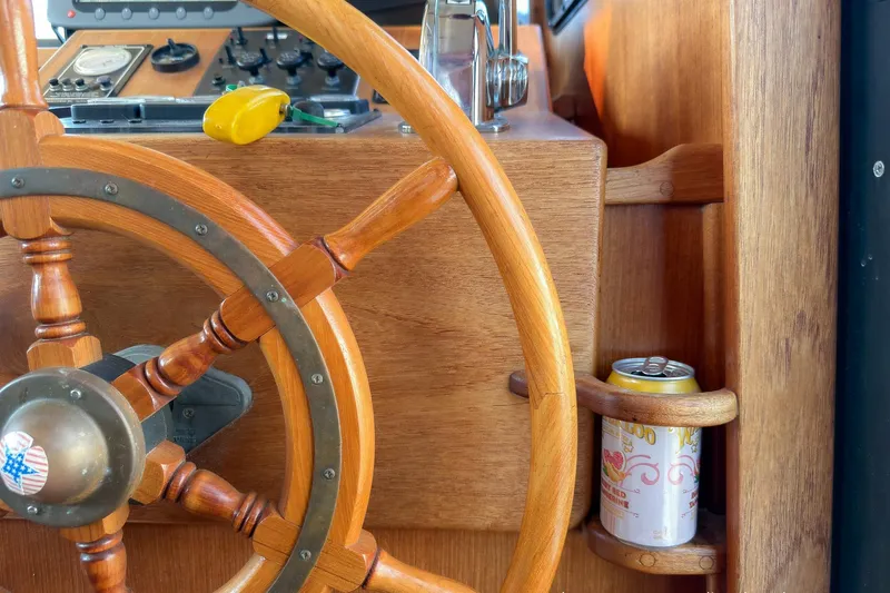 Dee Gee Yacht Photos Pics Wooden helm of 1999 Nordic Tug 37 with drink holder and control panel.