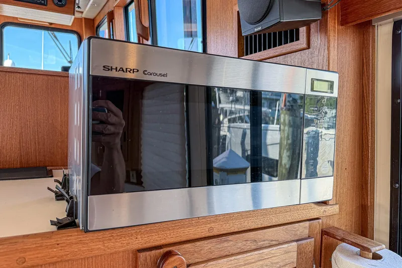 Dee Gee Yacht Photos Pics Sharp Carousel microwave inside a 1999 Nordic Tug 37 boat's wooden interior.