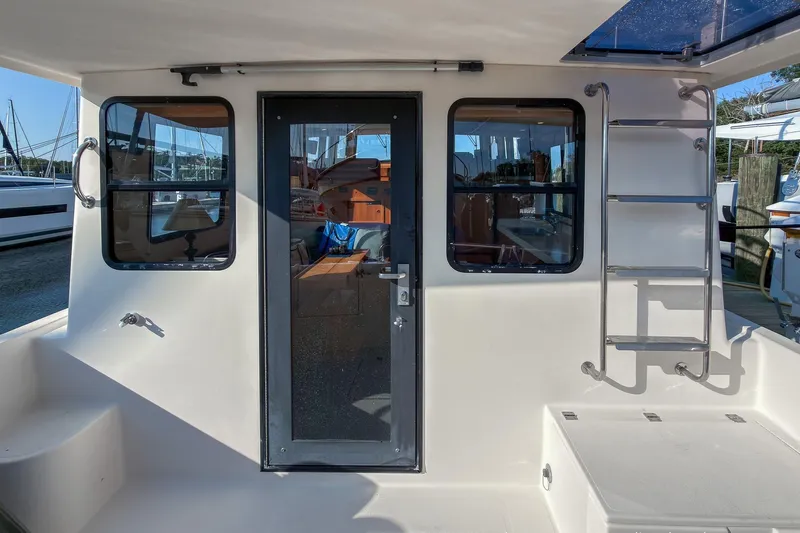 Dee Gee Yacht Photos Pics 1999 Nordic Tug 37 boat exterior with ladder and glass door, docked at marina.