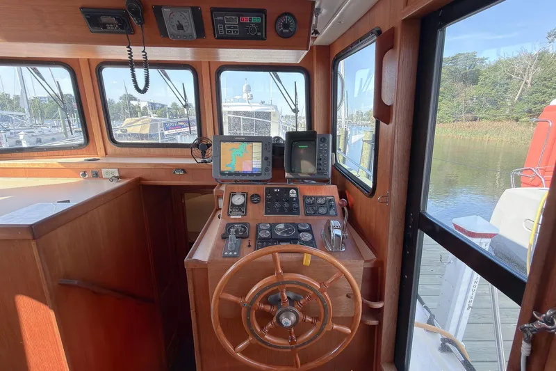 Dee Gee Yacht Photos Pics 1999 Nordic Tug 37 helm with wooden steering wheel and navigation equipment.