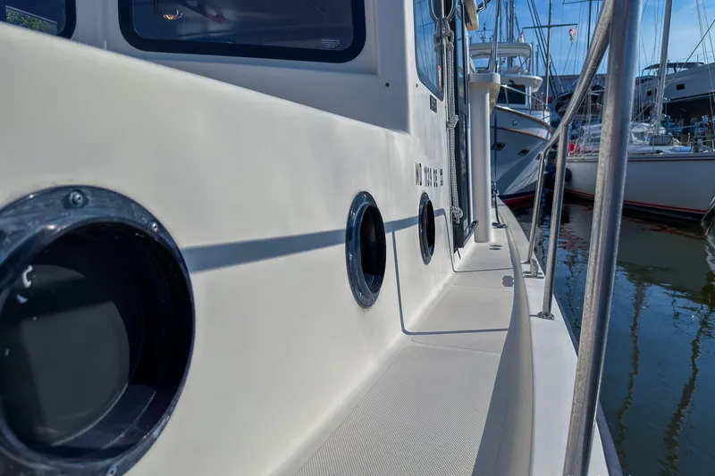 Dee Gee Yacht Photos Pics 1999 Nordic Tug 37 boat deck with portholes, docked in a marina.