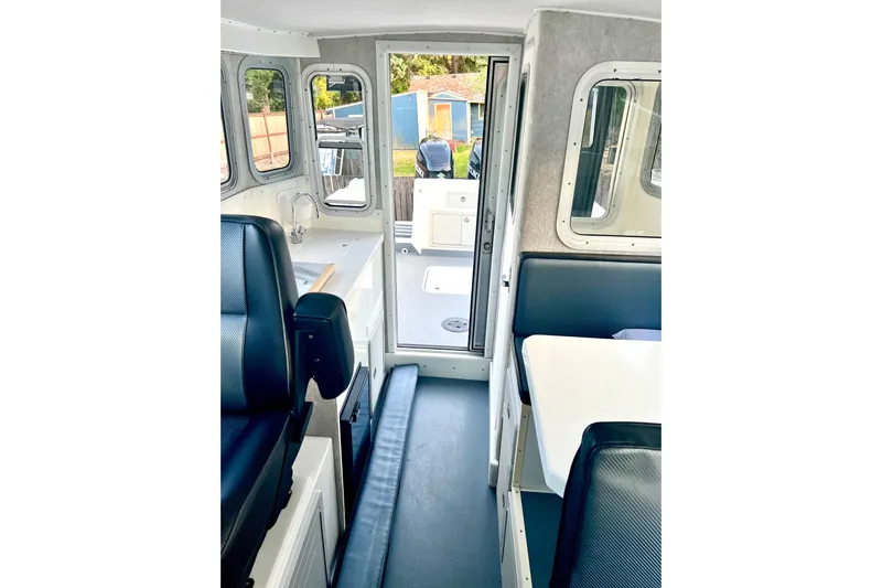  Yacht Photos Pics Interior of 2017 BAMF West Coast 25 excursion boat, featuring seating and windows.