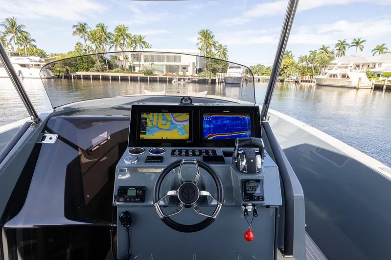 First Class Yacht Photos Pics 2022 Tesoro T38 Cruiser dashboard with navigation screens, steering wheel, and waterfront view.