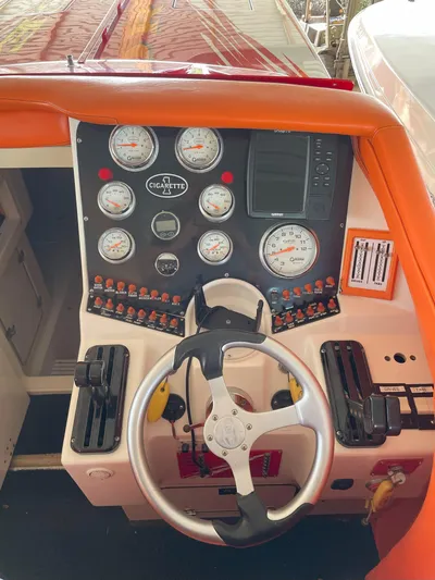 Driven Yacht Photos Pics Dashboard of a 2002 Cigarette ROUGH RIDER boat with gauges and steering wheel.