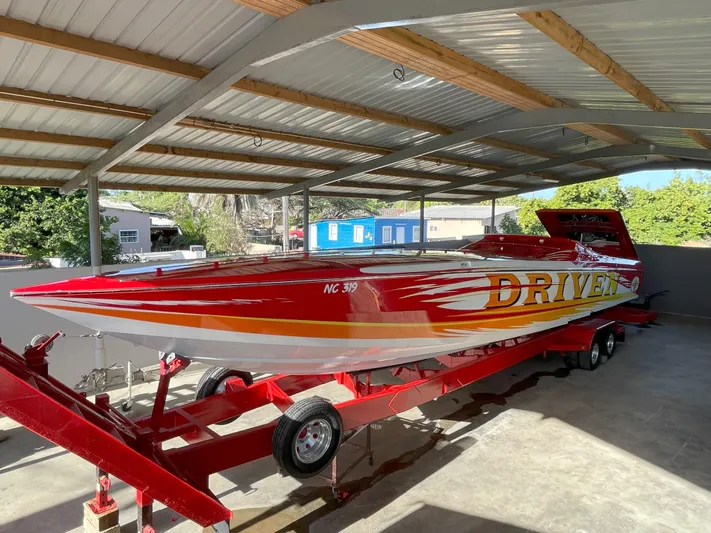 Driven Yacht Photos Pics 2002 Cigarette ROUGH RIDER speedboat on trailer under metal canopy.