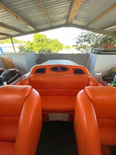 Driven Yacht Photos Pics 2002 Cigarette ROUGH RIDER boat with vibrant orange seating under a metal roof.