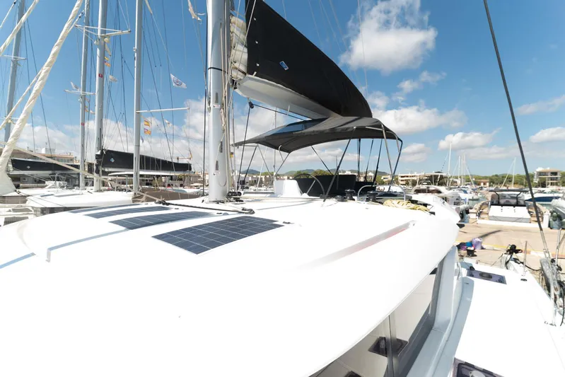  Yacht Photos Pics 2023 Lagoon 46 catamaran docked at marina under clear blue sky.