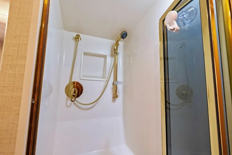 Summer Salt Yacht Photos Pics Shower area in 2006 Viking 56 Convertible yacht with gold fixtures and glass door.