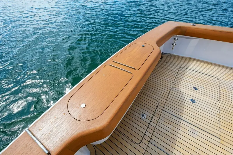 Summer Salt Yacht Photos Pics 2006 Viking 56 Convertible yacht deck with teak finish, overlooking calm blue water.