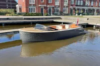 Modern GS 27 boat docked in a canal, with brick buildings in the background, 2022 model.