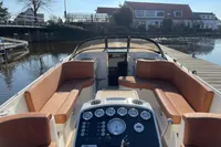 2022 GS 27 boat interior with tan seating and control panel, docked by a calm waterfront.