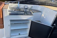 Compact boat kitchenette with sink, storage shelves, and open cabinet on GS 27 model, 2022.