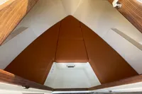 Interior cabin of 2022 GS 27 boat with brown cushions and wood accents.