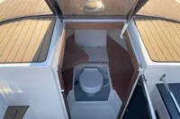 2022 GS 27 boat interior with compact cabin toilet and wooden accents.