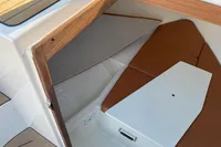 Interior cabin of 2022 GS 27 boat with brown seating and wooden accents.