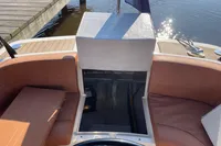 2022 GS 27 boat interior with open storage, brown seating, and dockside view.