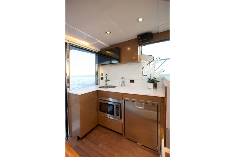  Yacht Photos Pics Modern kitchen interior of 2026 Cruisers Yachts 42 Cantius with sleek appliances and ocean view.
