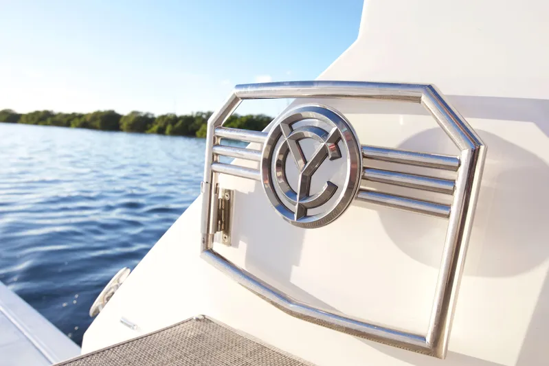 Yacht Photos Pics 2026 Cruisers Yachts 42 Cantius emblem on a boat with scenic water backdrop.