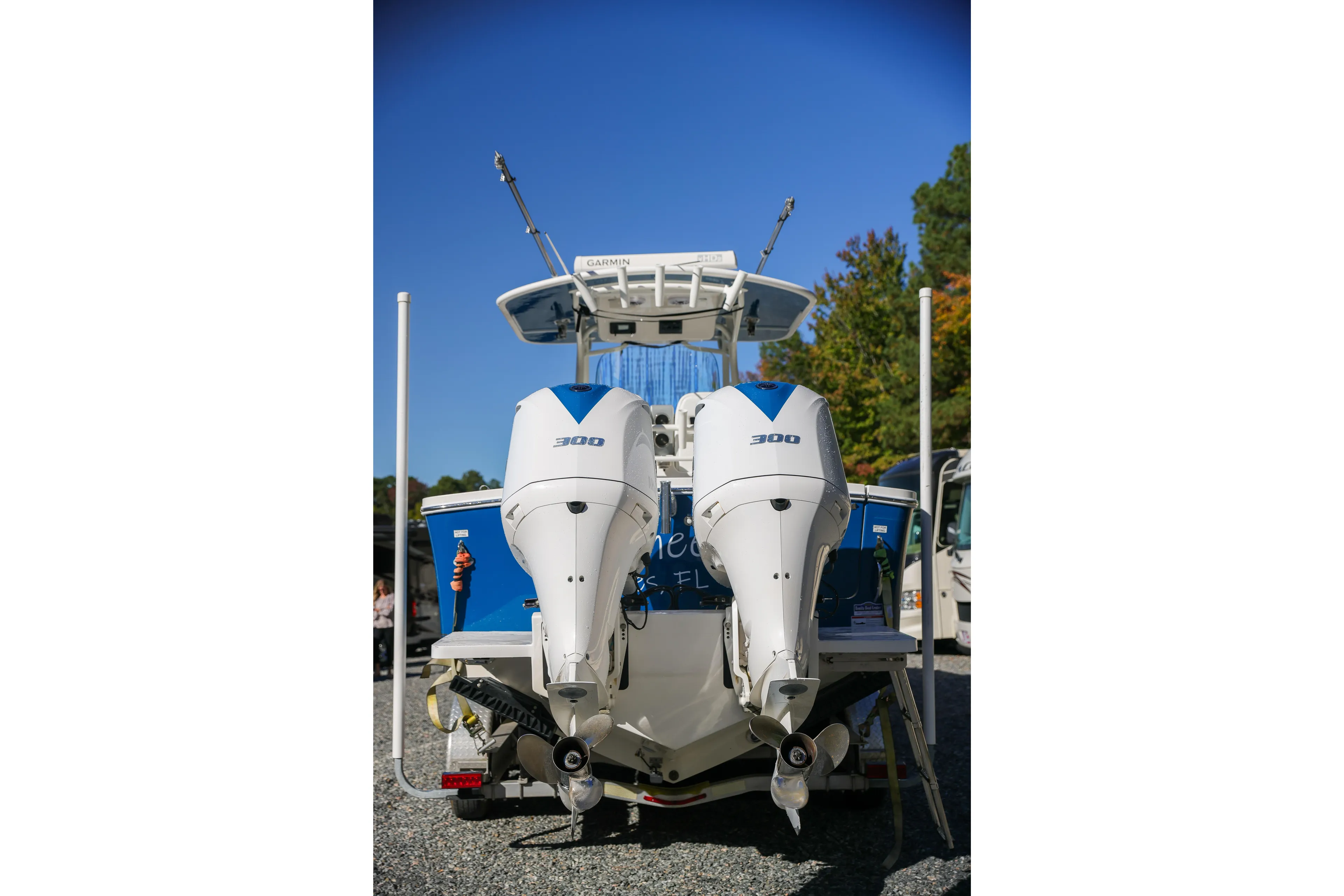  Yacht Photos Pics 2019 Regulator 28 boat with dual 300 horsepower outboard engines, parked on gravel.