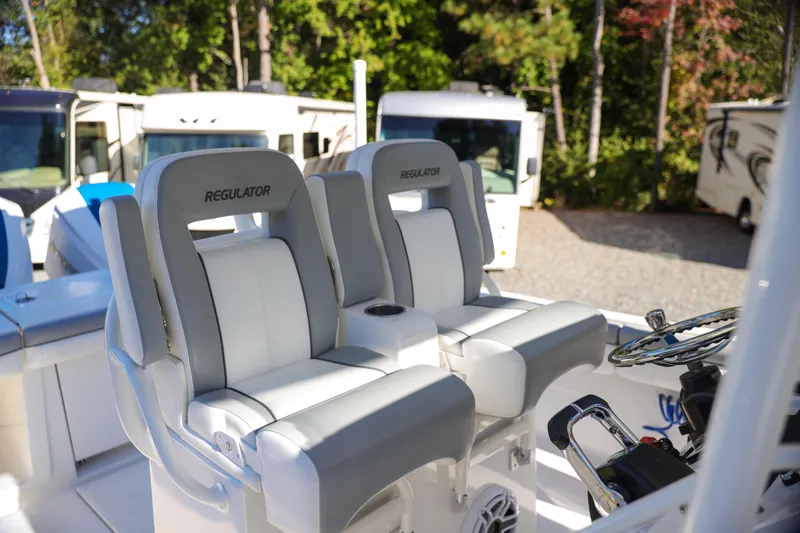  Yacht Photos Pics 2019 Regulator 28 boat seats with steering wheel, parked near RVs.