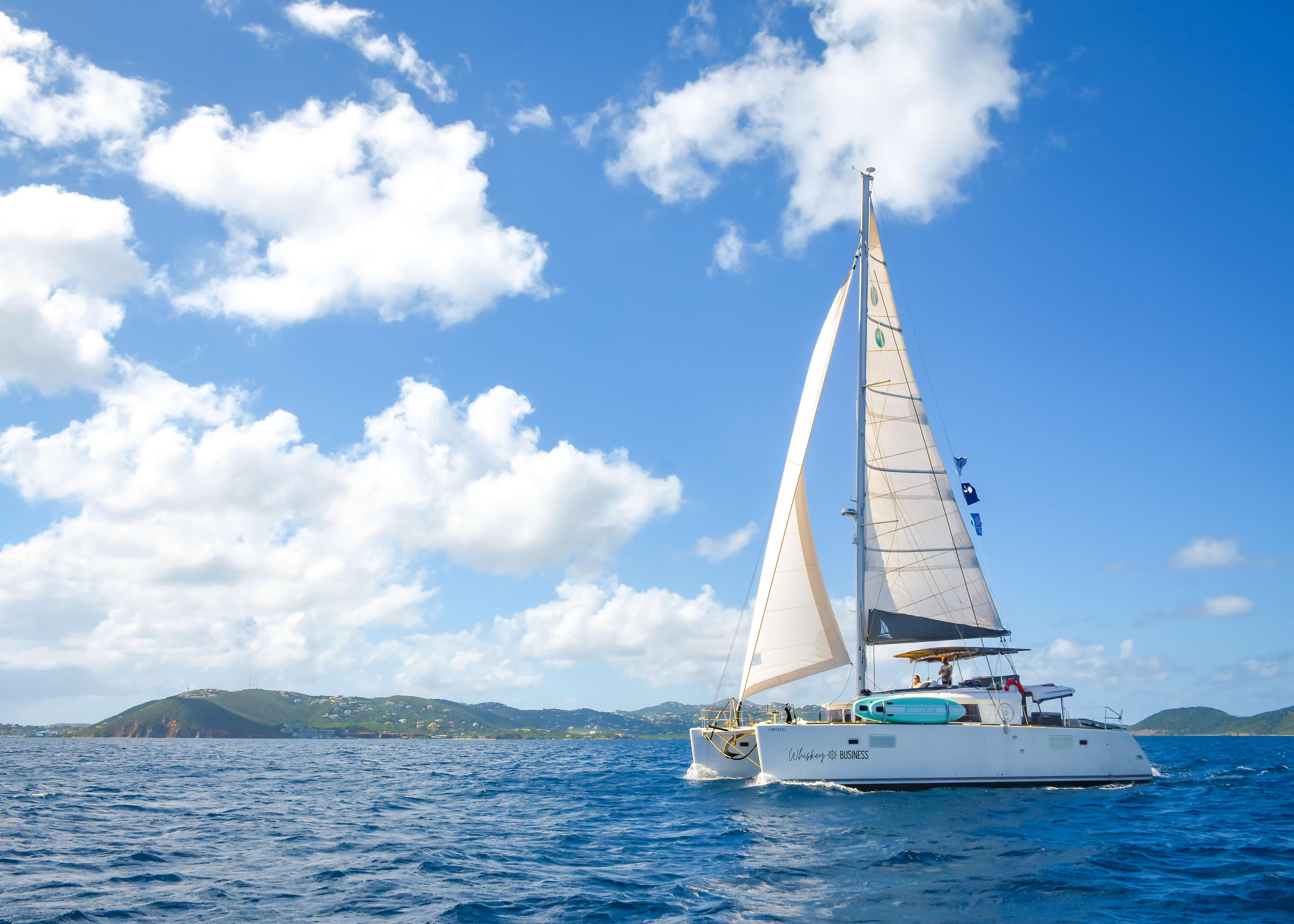 Lagoon 450F catamaran sailing on blue ocean under clear sky, 2015 model.