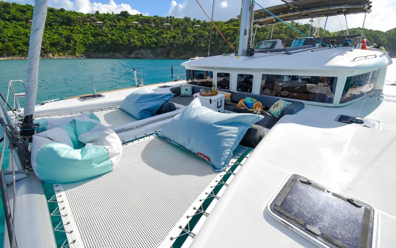Whiskey Business Yacht Photos Pics 2015 Lagoon 450F catamaran with comfortable deck seating, anchored in a scenic bay.
